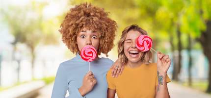 VRK Zahnzusatzversicherung – Zwei junge Frauen mit Lutschern in der Hand.
