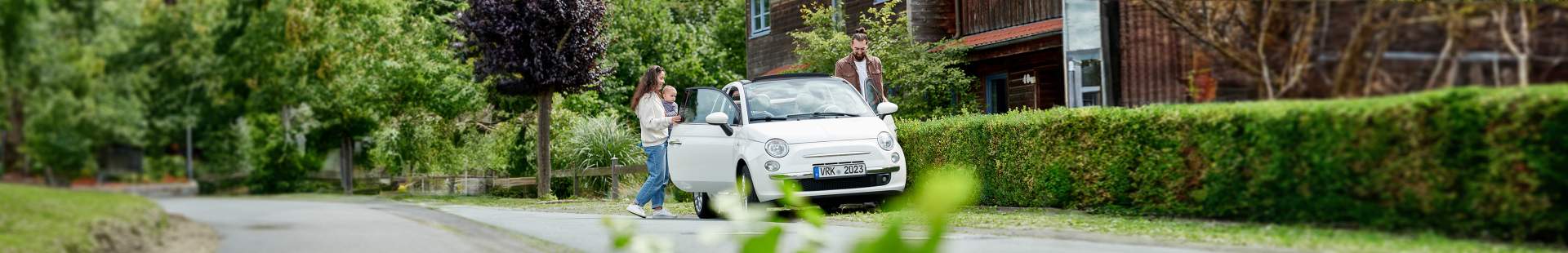 VRK Kfz-Versicherung –  Eine junge Familie steigt in ihr Auto ein.
