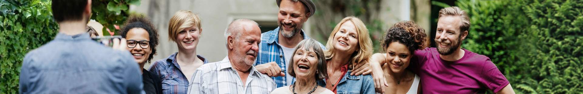 VRK Pflegeversicherung – Eine glückliche Familie mit mehreren Generationen lässt sich fotografieren.