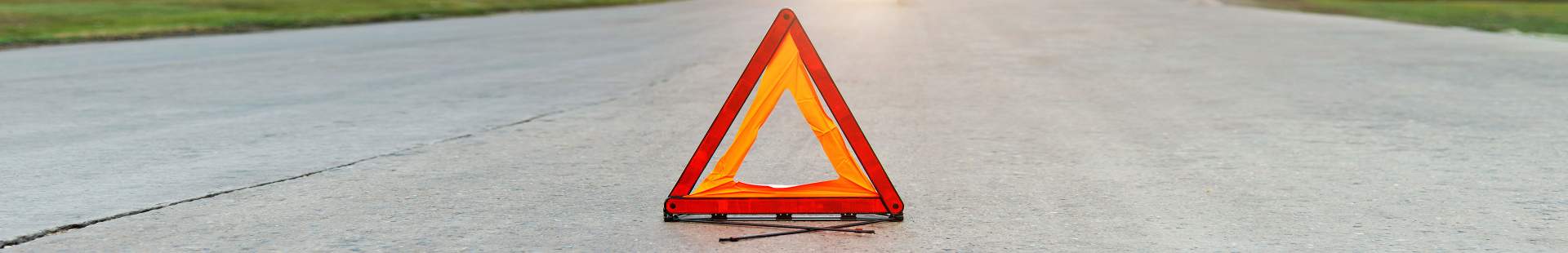 VRK Unfallhilfe – Ein Warndreieck auf einer Straße