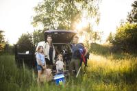 Familie im Grünen vor Elektroauto Familie im Grünen vor Elektroauto