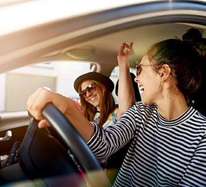 VRK Zusatzschutz – Junge Frau sitzt mit ihrer Freundin in Ihrem Auto.