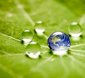 VRK Unsere Nachhaltigkeit – Die Erde in einem Wassertropfen auf einem grünen Blatt.