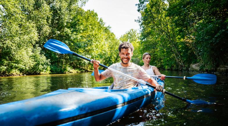 VRK Kranken-Zusatzversicherungen – Ein junges Paar fährt mit dem Kanu auf dem Fluss.