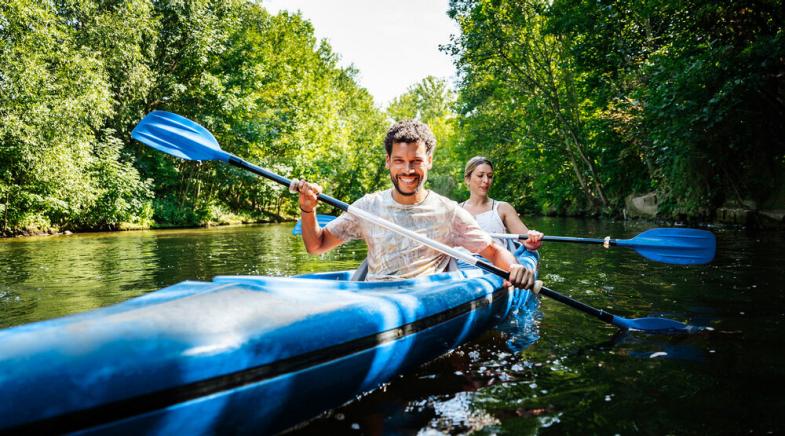 VRK Kranken-Zusatzversicherungen – Ein junges Paar fährt mit dem Kanu auf dem Fluss.