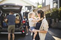 Familie steht am Auto