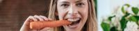 Frau beißt in eine Karotte