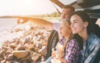 VRK Autoversicherung VRK Autoversicherung – Familie sitzt im geöffnetem Kofferaum und schaut auf das Meer.