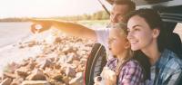 VRK Autoversicherung VRK Autoversicherung – Familie sitzt im geöffnetem Kofferaum und schaut auf das Meer.