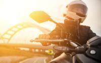 VRK Motorradversicherung VRK Motorradversicherung – Eine Frau fährt bei Sonnenuntergang auf einem Motorrad