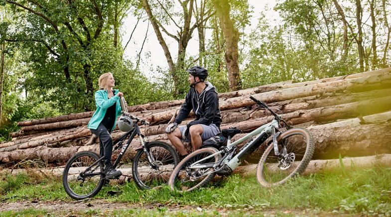 VRK Pdelec-Versicherung – Ein junges Paar fährt mit E-Bikes durch die Natur.